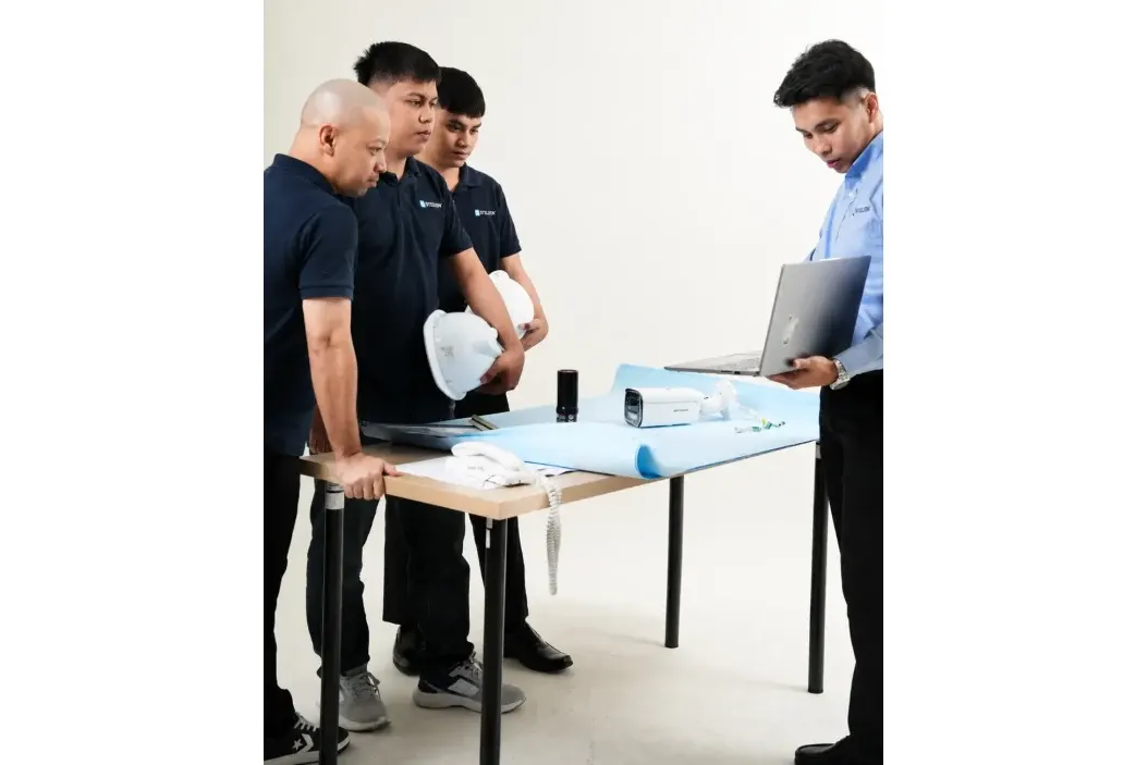 Stelsen service team reviewing building plans with a property manager, alongside a CCTV camera and maintenance equipment